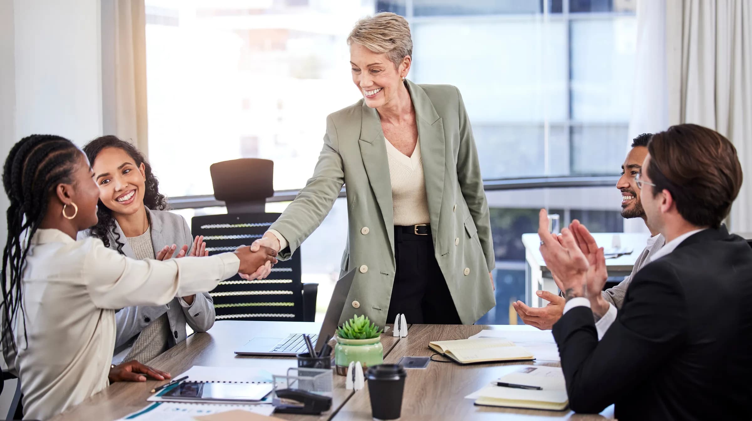 A team shaking hands and celebrating after winning a contract